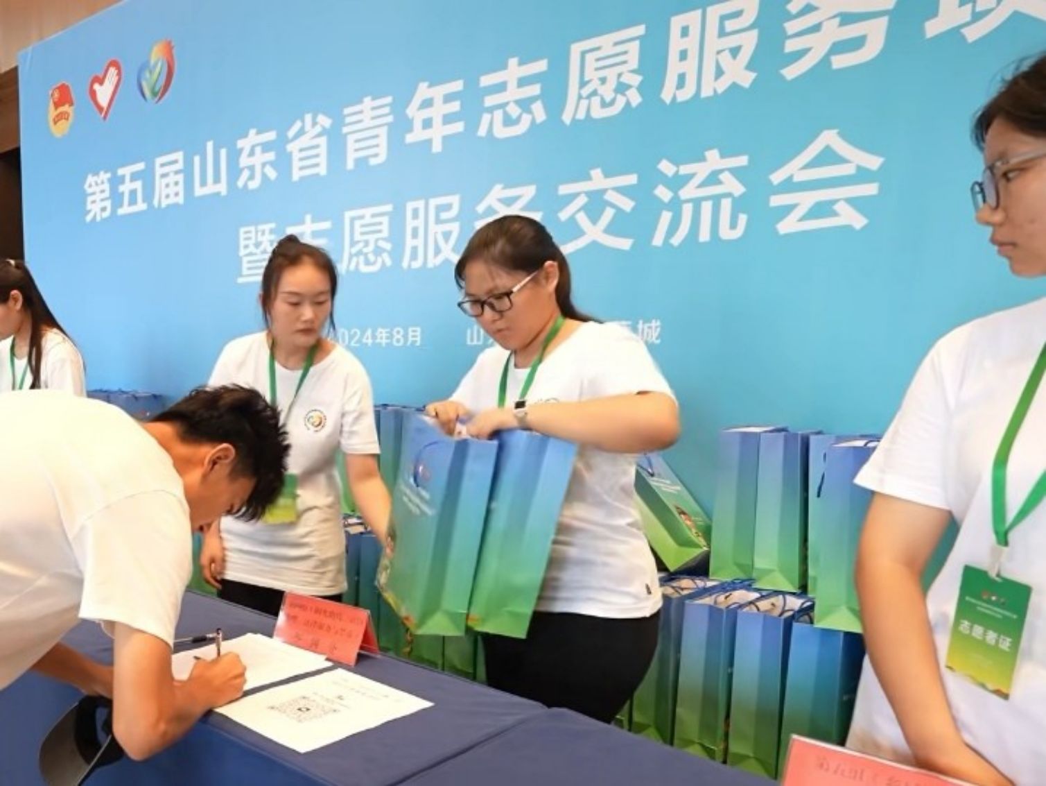 圖為“新奇”實踐團成員給參賽者分發(fā)會務(wù)包